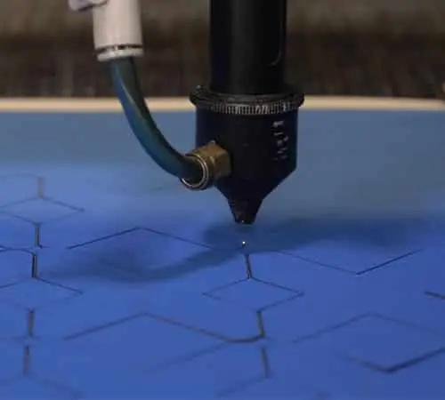 Lazer kesim makinesi mavi kumaş üzerine geometrik desen keserken